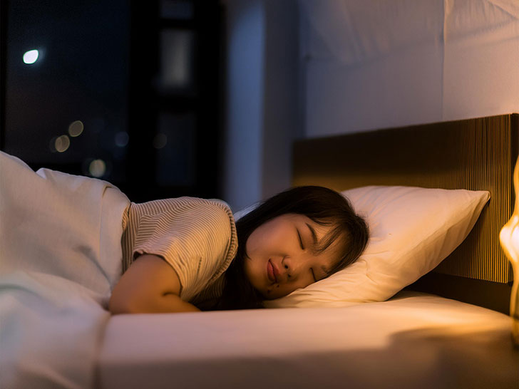 ベッドで眠る若い女性