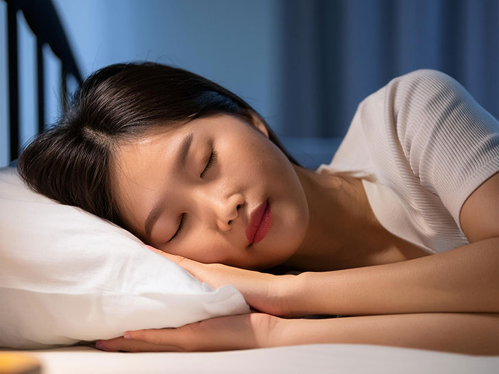 ベッドで眠る若い女性