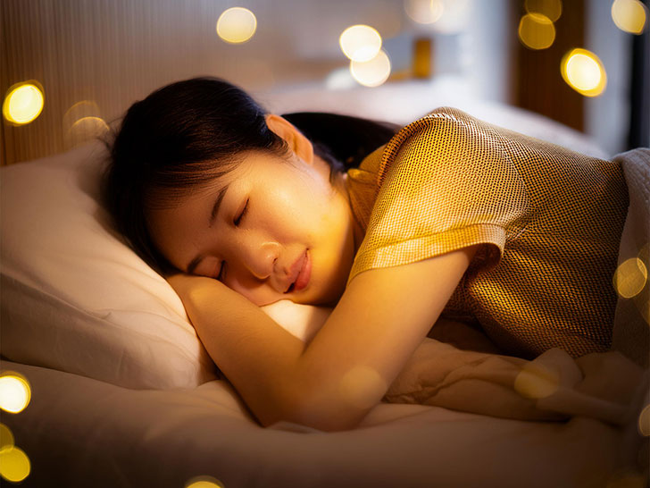 ベッドで眠る若い女性