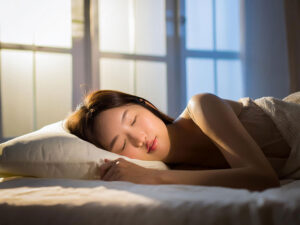 ベッドで眠る若い女性