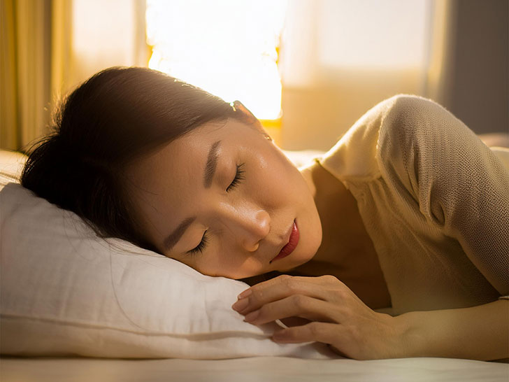 ベッドで眠る若い女性