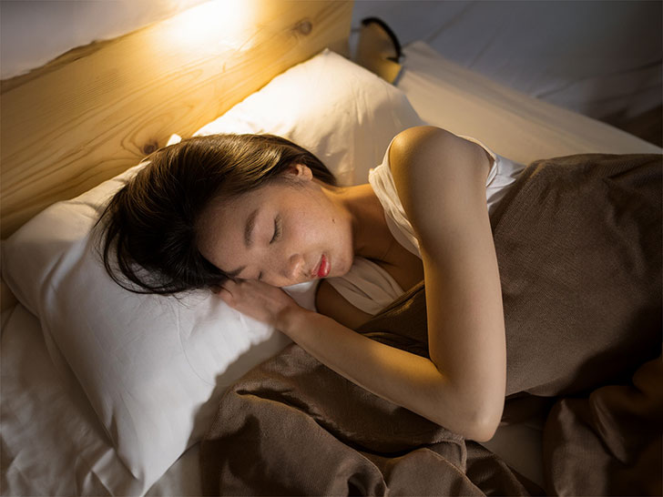 ベッドで眠る若い女性