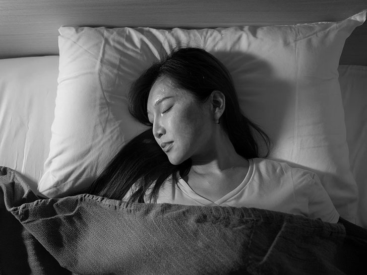 ベッドで眠る若い女性