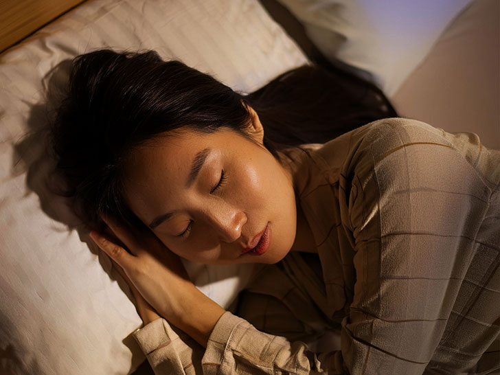 ベッドで眠る若い女性