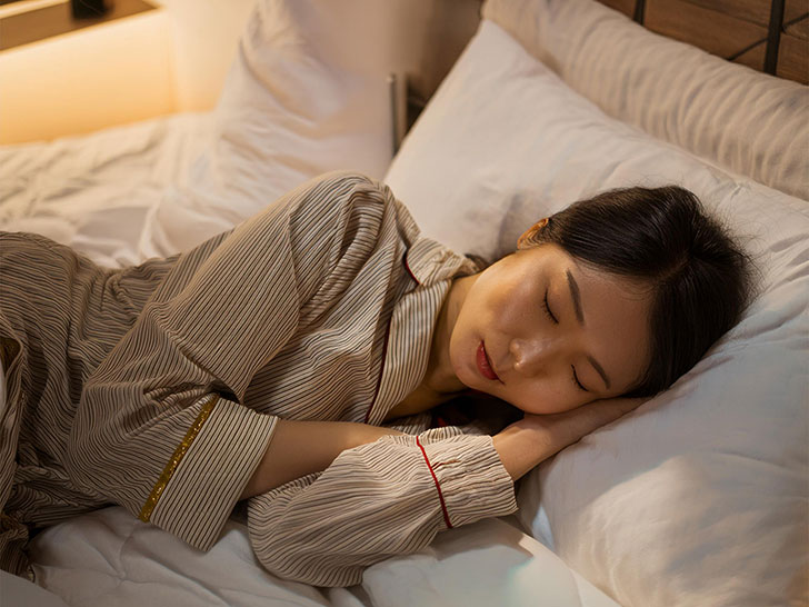 ベッドで眠る若い女性