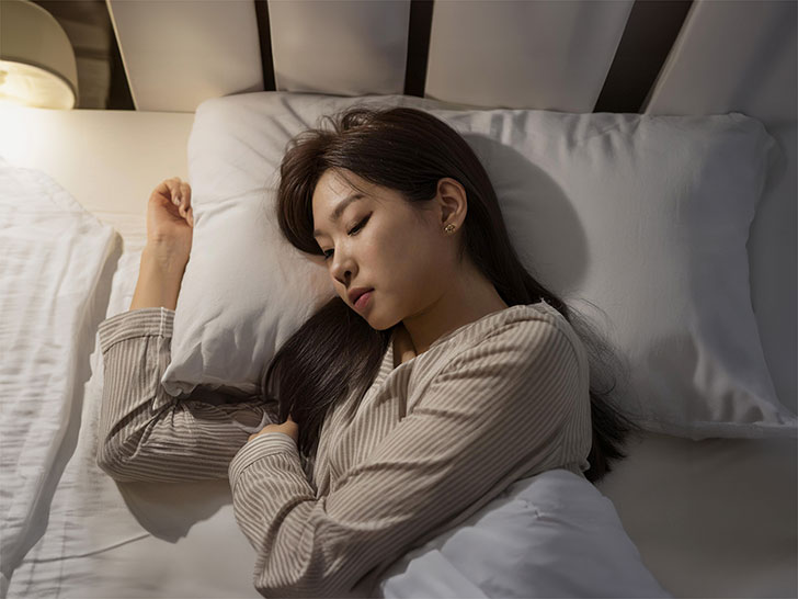 ベッドで眠る若い女性