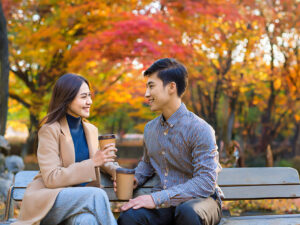 秋の公園でデートする若いカップル