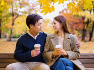 秋の公園でデートする若いカップル