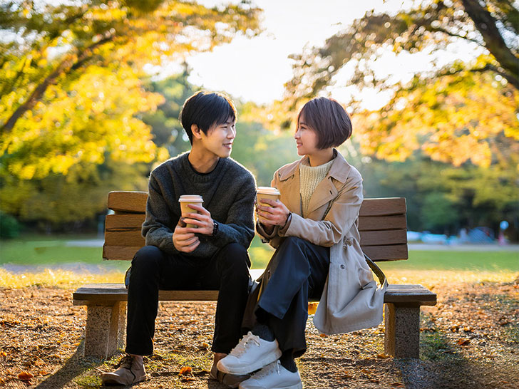 秋の公園でデートする若いカップル