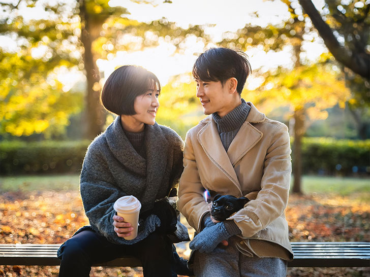 秋の公園でデートする若いカップル