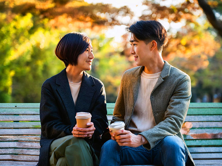 秋の公園でデートする若いカップル