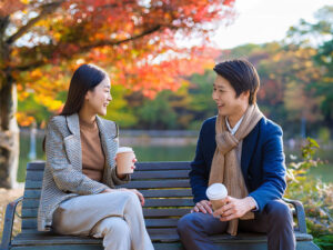 秋の公園でデートする若いカップル