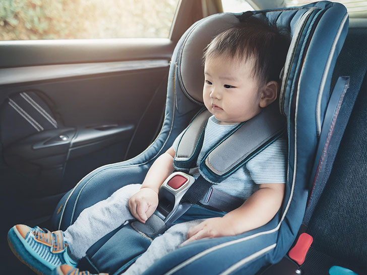 車のチャイルドシートに座る赤ちゃん