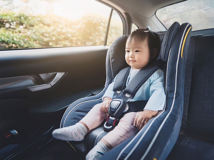 車のチャイルドシートに座る赤ちゃん