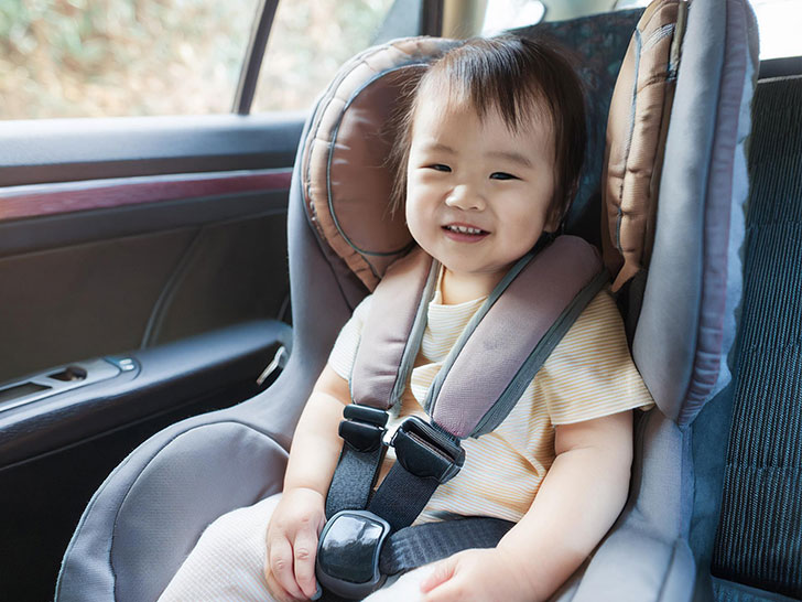 車のチャイルドシートに座る赤ちゃん