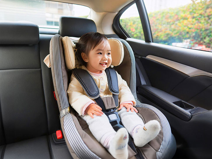 車のチャイルドシートに座る赤ちゃん