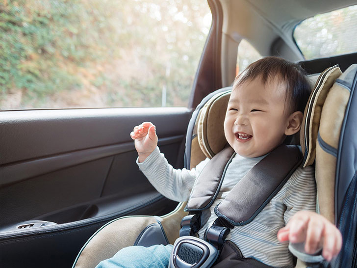 車のチャイルドシートに座る赤ちゃん