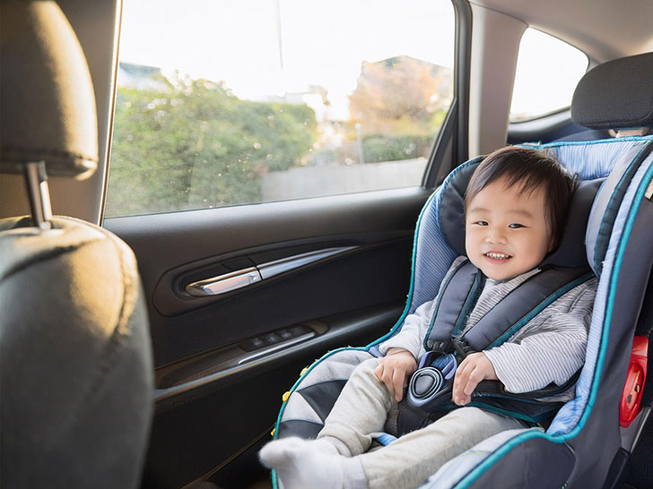 車のチャイルドシートに座る赤ちゃん