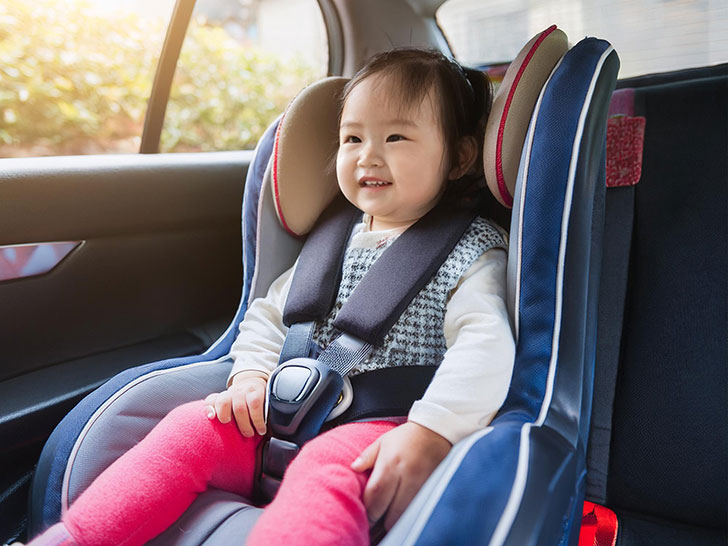 車のチャイルドシートに座る赤ちゃん