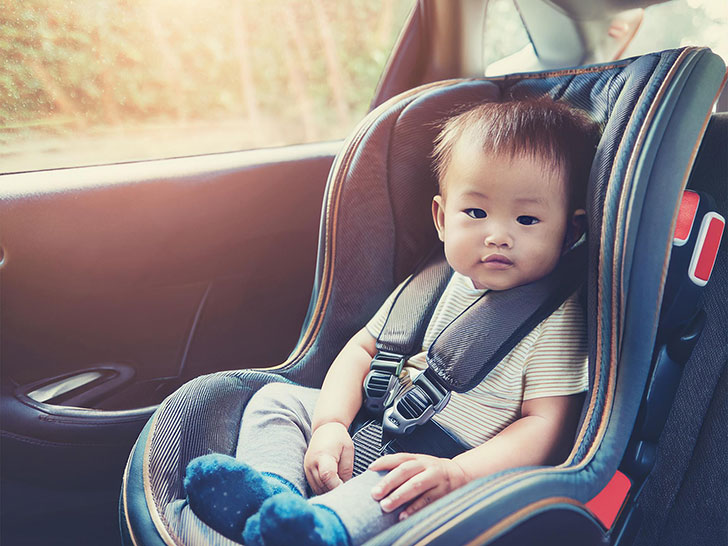 車のチャイルドシートに座る赤ちゃん