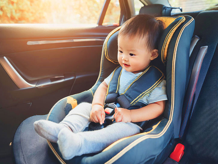 車のチャイルドシートに座る赤ちゃん