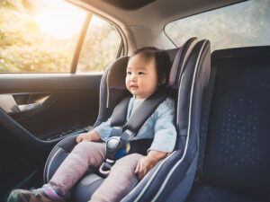 車のチャイルドシートに座る赤ちゃん