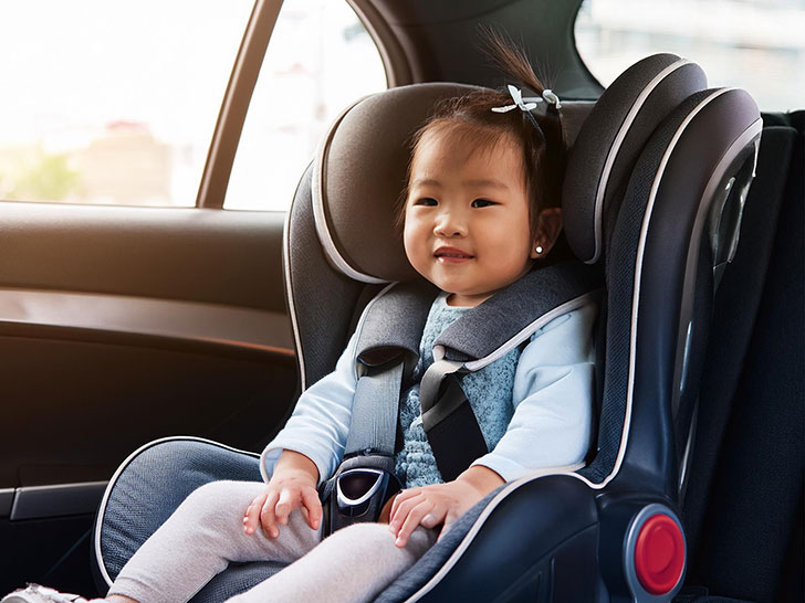 車のチャイルドシートに座る赤ちゃん