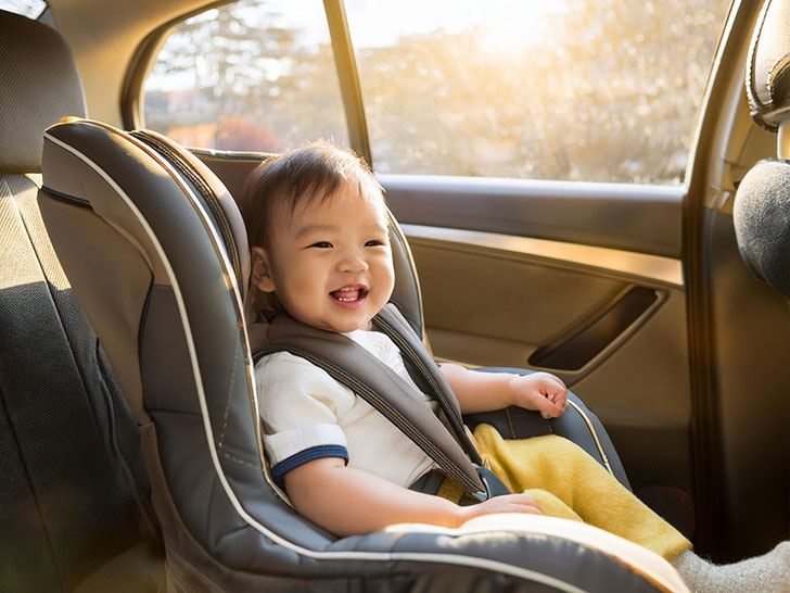 車のチャイルドシートに座る赤ちゃん