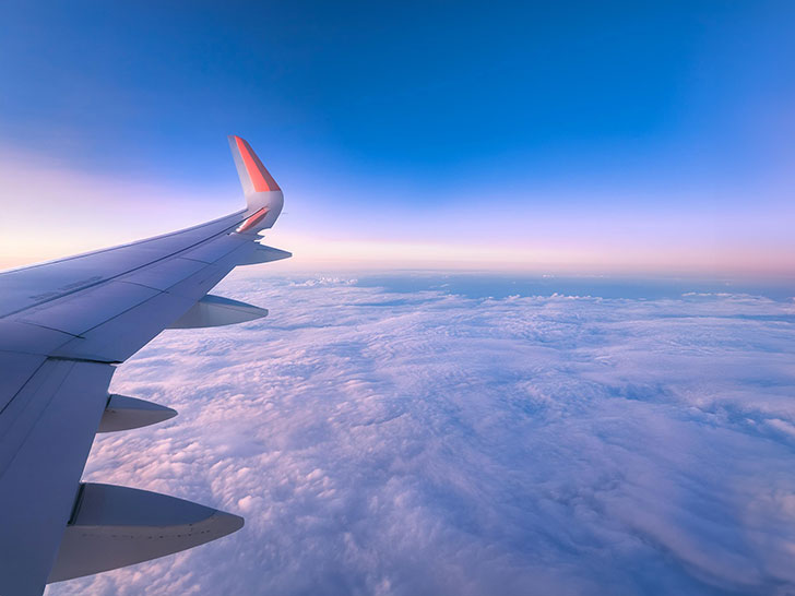 飛行機の窓から見た翼と雲