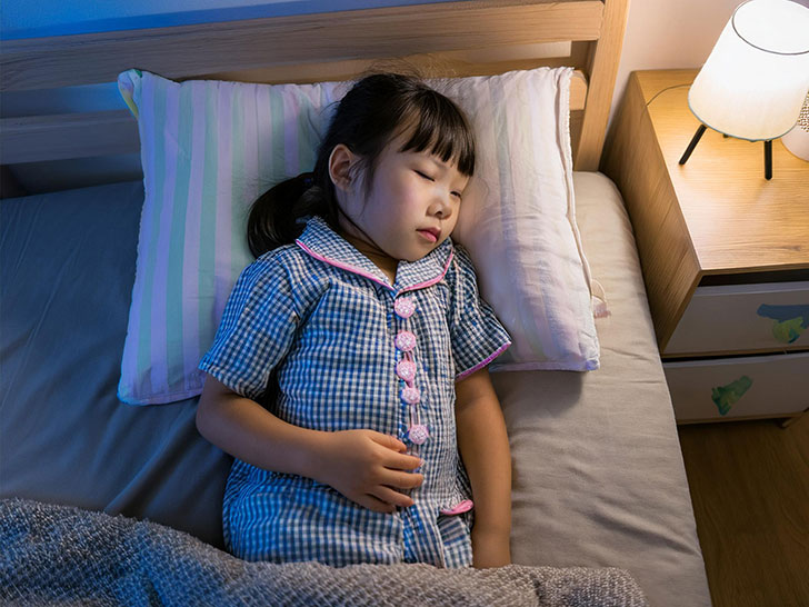 ベッドで眠る小さな女の子