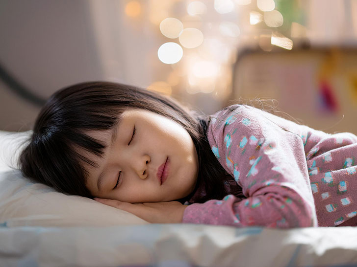 ベッドで眠る小さな女の子