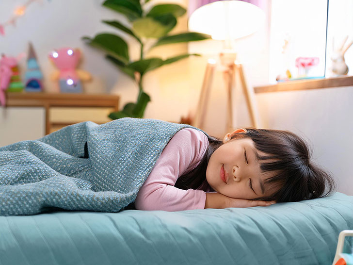 ベッドで眠る小さな女の子