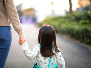 母親と手をつなぐ女の子の後ろ姿