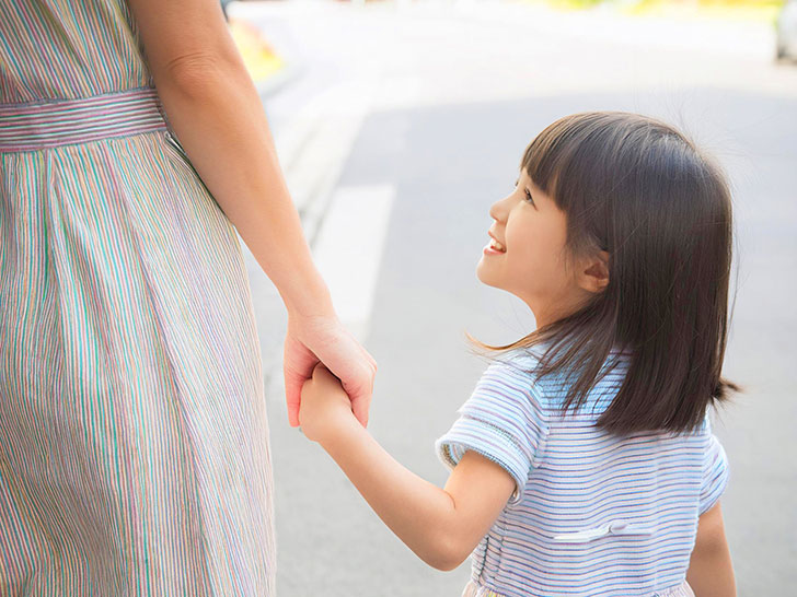 母親と手をつなぐ女の子の後ろ姿