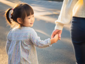 母親と手をつなぐ女の子の後ろ姿