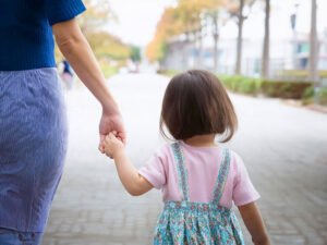 母親と手をつなぐ女の子の後ろ姿