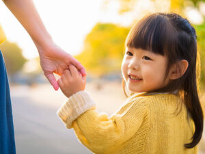 母親と手をつなぐ女の子の後ろ姿