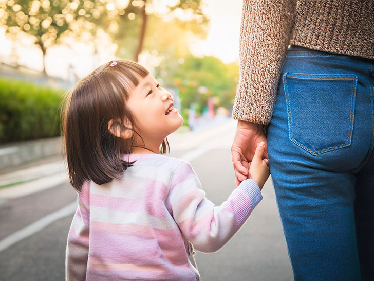 母親と手をつなぐ女の子の後ろ姿