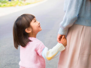 母親と手をつなぐ女の子の後ろ姿