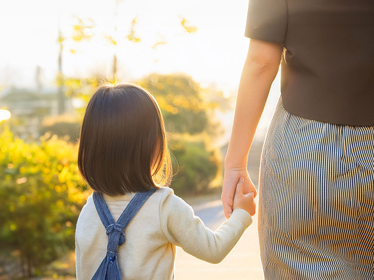 母親と手をつなぐ女の子の後ろ姿