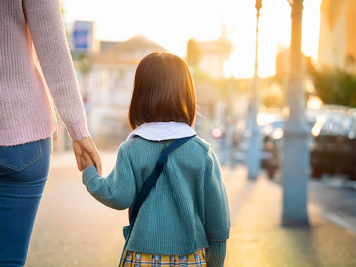 母親と手をつなぐ女の子の後ろ姿