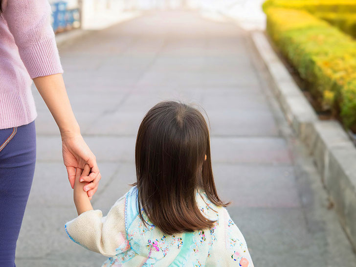 母親と手をつなぐ女の子の後ろ姿