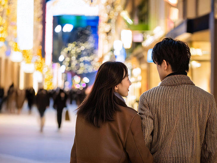 冬の街を歩くカップルの後ろ姿