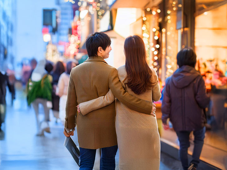 冬の街を歩くカップルの後ろ姿