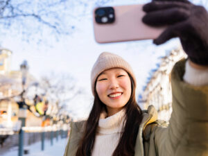 冬の観光地で自撮りをする若い女性