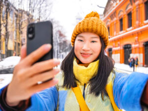 冬の観光地で自撮りをする若い女性