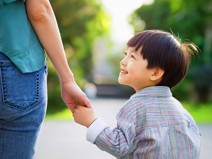 母親と手をつなぐ男の子の後ろ姿