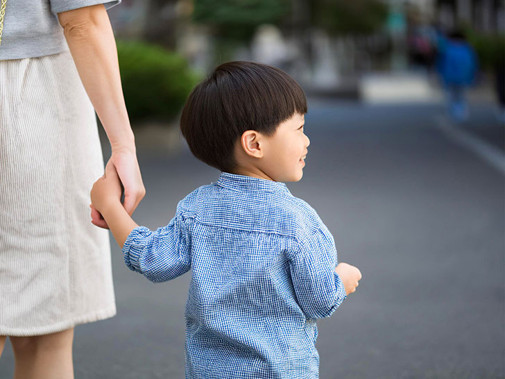 母親と手をつなぐ男の子の後ろ姿