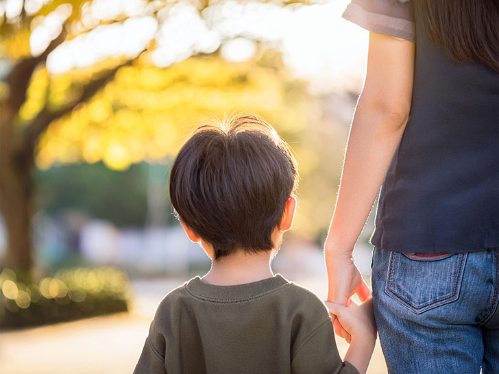 母親と手をつなぐ男の子の後ろ姿