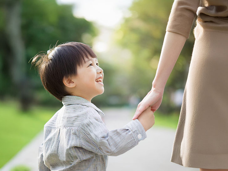 母親と手をつなぐ男の子の後ろ姿